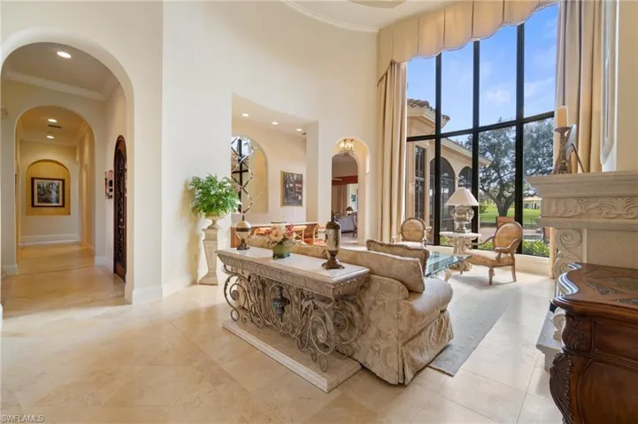 Living room with a towering ceiling and ornamental molding
