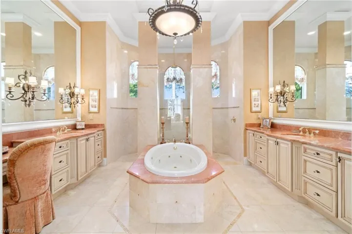 Bathroom featuring a relaxing tiled tub, vanity, and crown molding