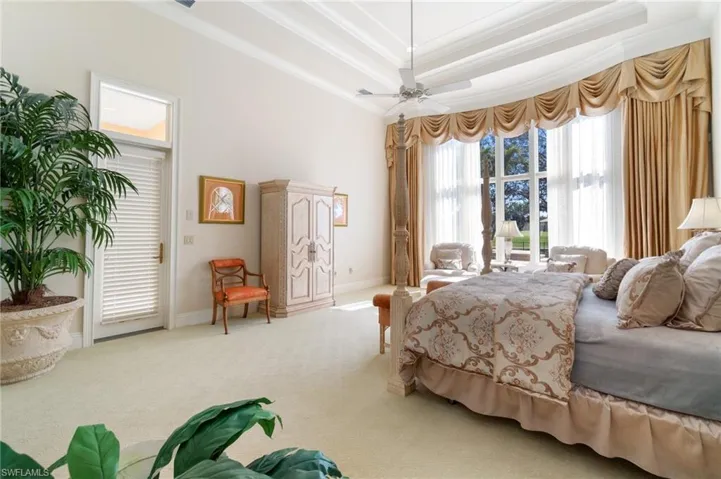 Bedroom featuring carpet floors, access to exterior, ceiling fan, a raised ceiling, and crown molding