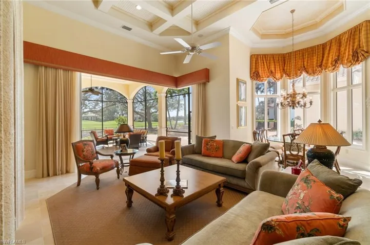 Sunroom / solarium with coffered ceiling, ceiling fan with notable chandelier, and beam ceiling