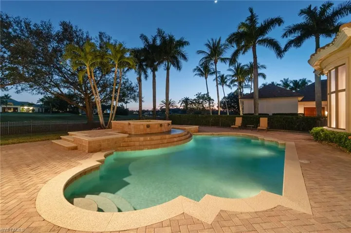Pool at dusk featuring a patio