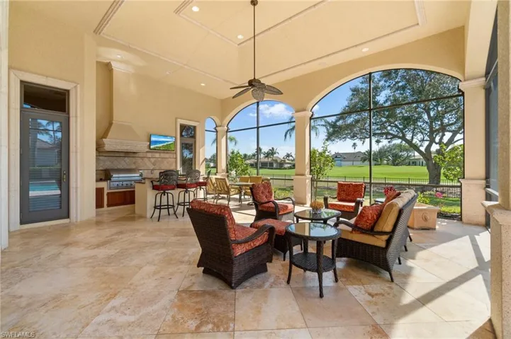 View of patio with a bar, outdoor lounge area, a grill, exterior kitchen, and ceiling fan