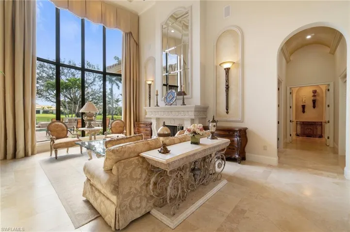 Sitting room featuring a high ceiling and a high end fireplace