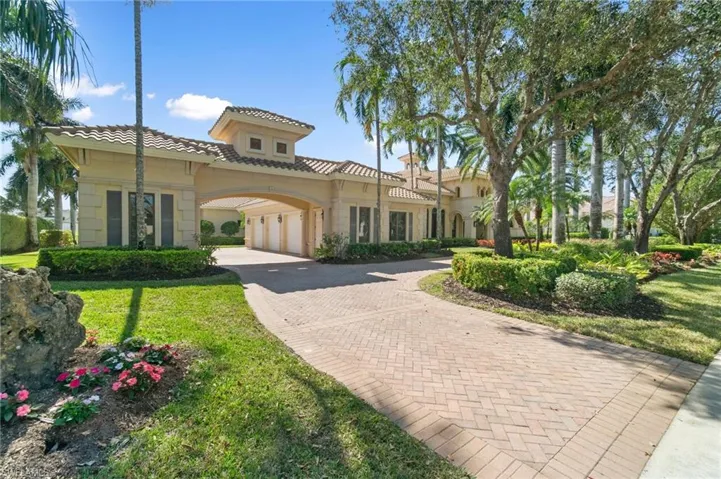 Mediterranean / spanish-style home with a garage and a front lawn