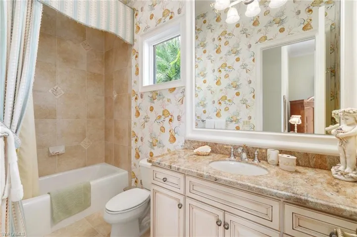 Full bathroom with shower / tub combo with curtain, vanity, and toilet