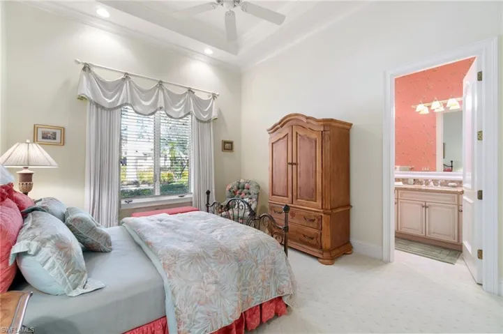 Carpeted bedroom featuring ornamental molding, sink, ensuite bathroom, and ceiling fan