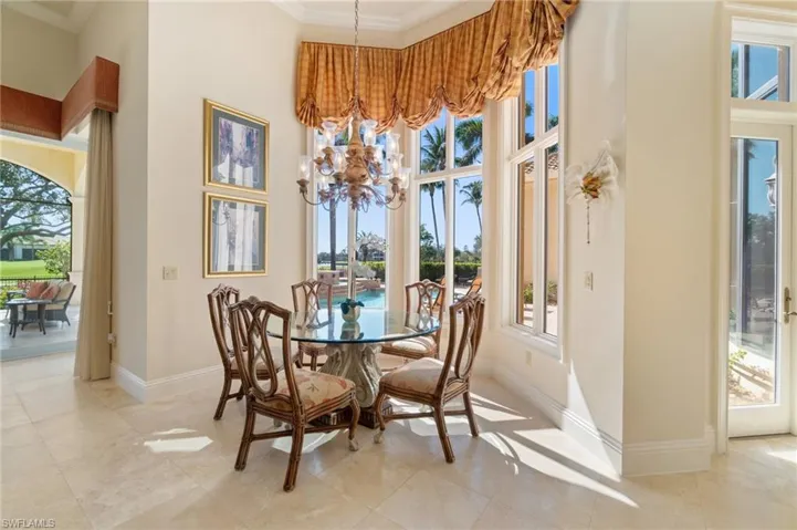 Dining space with ornamental molding, a towering ceiling, light tile patterned floors, and a chandelier