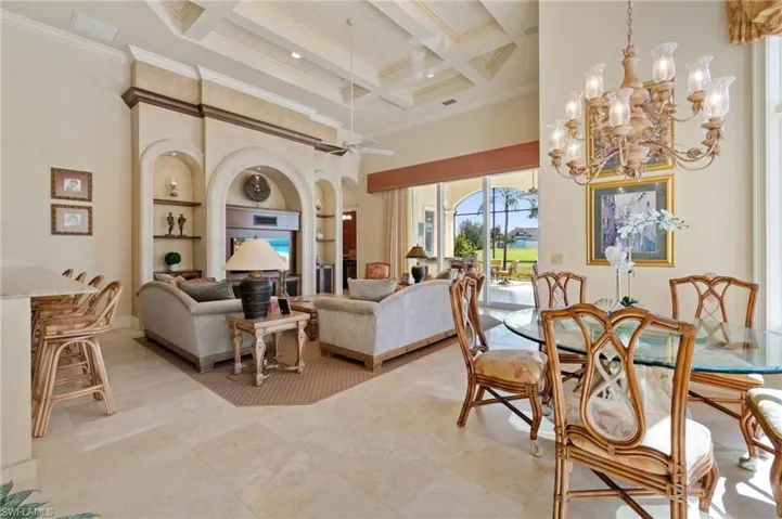 Dining room featuring beamed ceiling, crown molding, coffered ceiling, and a towering ceiling