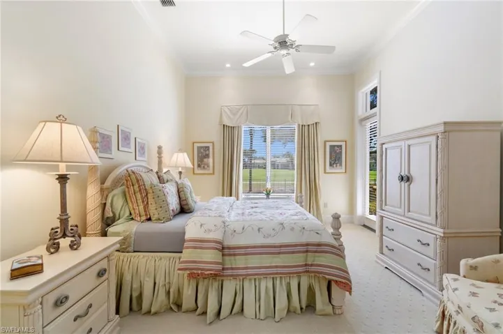 Carpeted bedroom featuring ornamental molding and ceiling fan