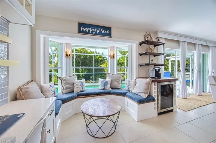 Living area featuring beverage cooler, healthy amount of natural light, and light tile patterned flooring