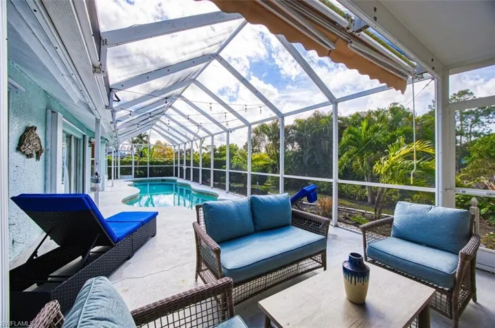 Swimming pool featuring a patio, outdoor lounge area, a sunroom, and glass enclosure