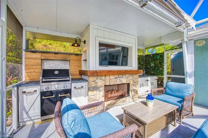 View of patio / terrace with an outdoor kitchen and an outdoor stone fireplace