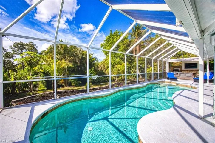 Outdoor pool with a sunroom, a patio, and a lanai