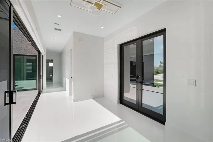Hall featuring french doors and recessed lighting