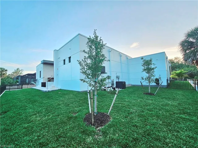 View of side of home with fence, a yard, and stucco siding