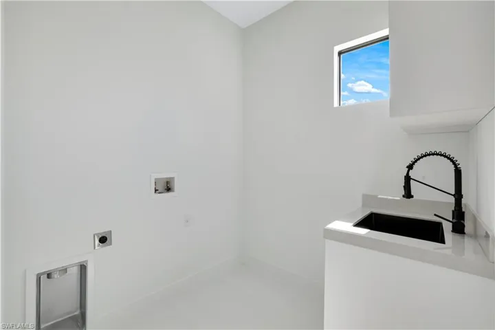 Laundry room featuring a sink, hookup for an electric dryer, baseboards, washer hookup, and laundry area