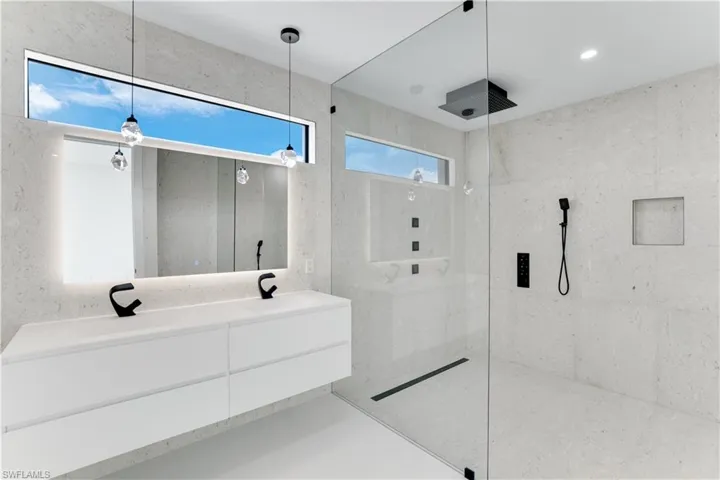 Bathroom with a sink, a walk in shower, and double vanity