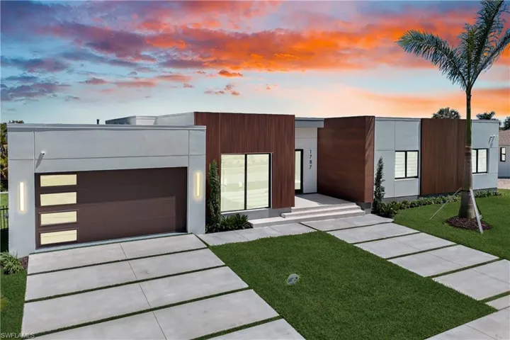 Modern home featuring an attached garage, a lawn, stucco siding, and concrete driveway