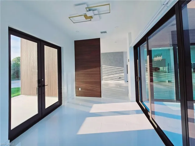 Hallway featuring french doors, tile patterned floors, and visible vents