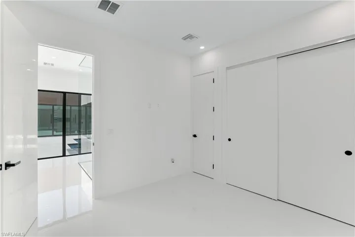 Unfurnished bedroom featuring attic access, visible vents, recessed lighting, and a closet