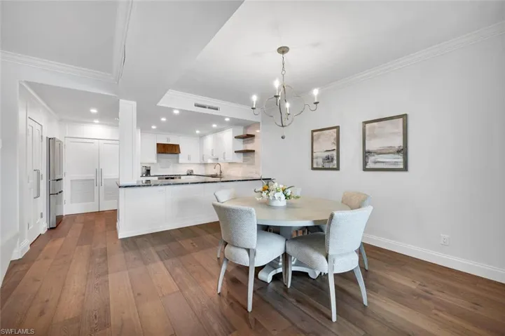 Dining space featuring crown molding, dark wood-type flooring, a chandelier, and recessed lighting