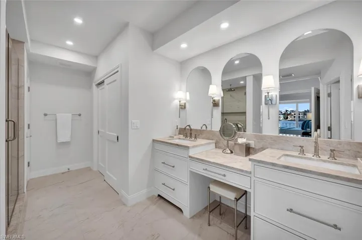 Full bathroom with connected bathroom, double vanity, light marble finish floors, recessed lighting, and a stall shower
