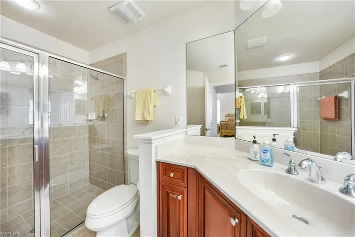 Bathroom with toilet, walk in shower, and vanity