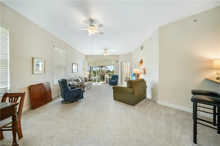 Carpeted living room featuring ceiling fan