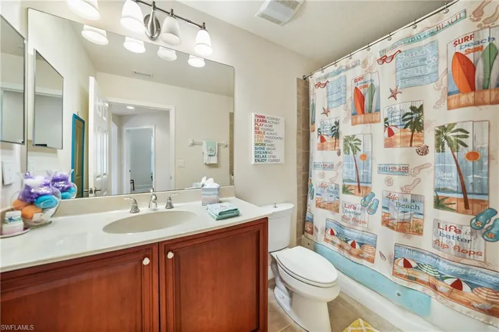 Full bathroom featuring tile patterned flooring, shower / tub combo with curtain, toilet, and vanity