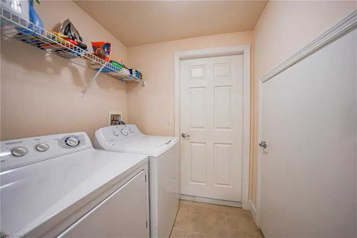 Washroom featuring washer and clothes dryer and light tile patterned floors