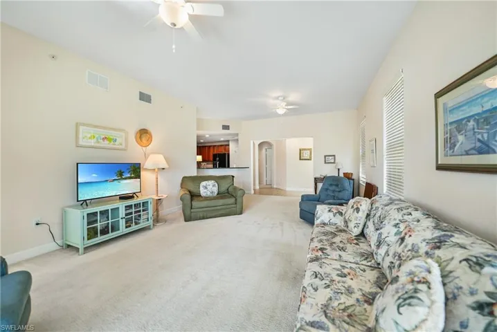 Carpeted living room with ceiling fan
