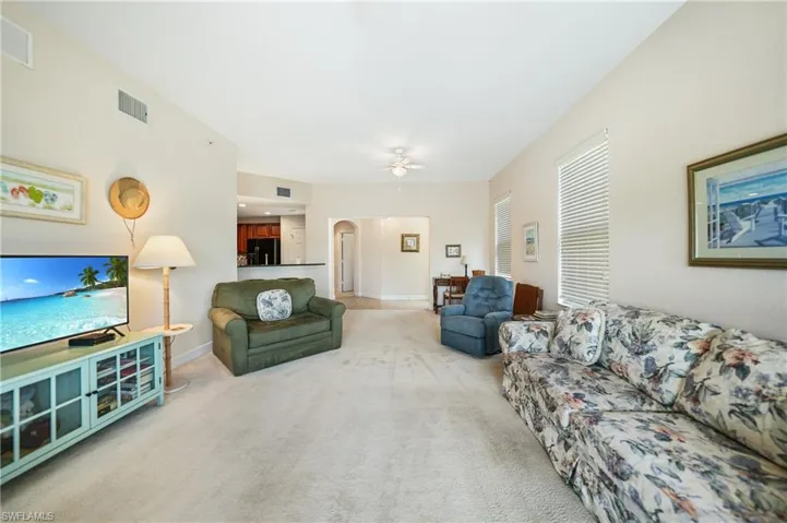 Carpeted living room featuring ceiling fan