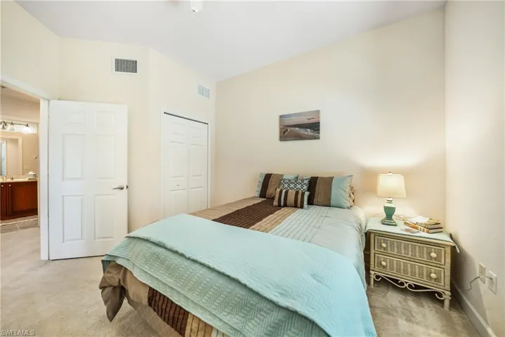 Carpeted bedroom with a closet and ensuite bathroom