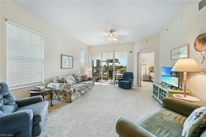 Living room with light colored carpet and ceiling fan