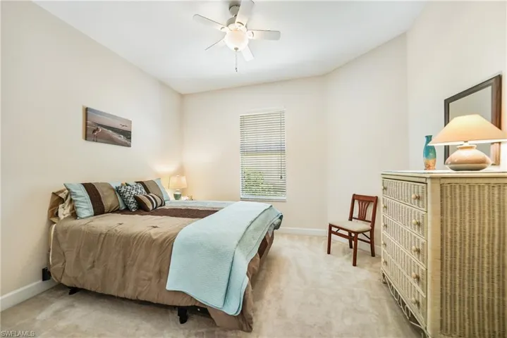 Carpeted bedroom featuring ceiling fan