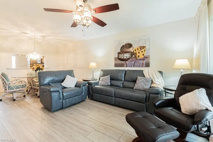 Living room with ceiling fan and light hardwood / wood-style flooring