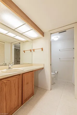 Bathroom featuring toilet, vanity, and tile patterned flooring
