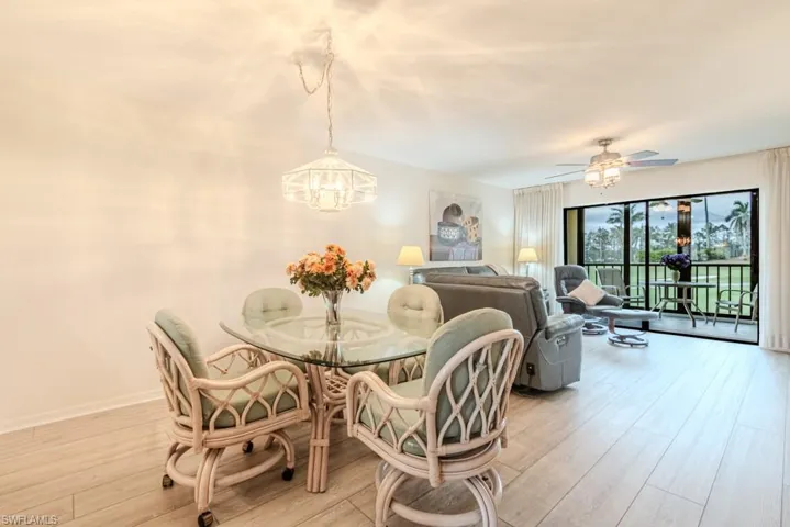 Dining area with ceiling fan with notable chandelier and light wood-type flooring