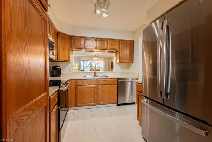 Kitchen with sink, stainless steel appliances, and light tile patterned flooring