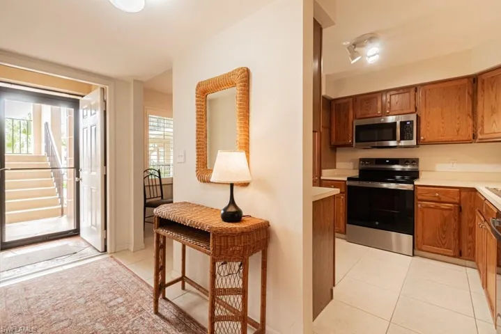Kitchen with light tile patterned floors, appliances with stainless steel finishes, and a healthy amount of sunlight