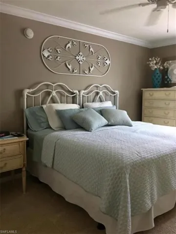 Bedroom with ornamental molding, carpet flooring, and ceiling fan