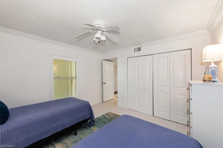 Bedroom featuring ornamental molding, a closet, and ceiling fan