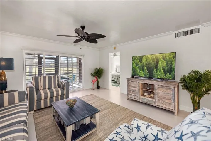 Living area featuring ornamental molding, a ceiling fan, and wood finished floors