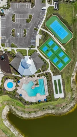 Aerial view showcasing a range of amenities including a tennis court, pickleball courts, and a resort-style pool with a separate circular pool
