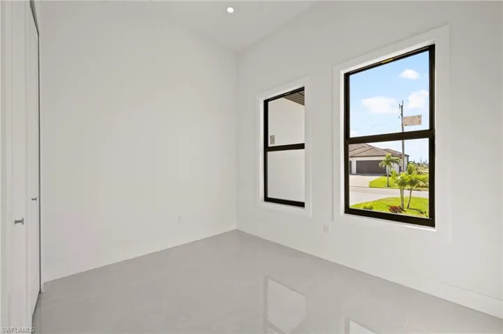 Spare room featuring finished concrete flooring, baseboards, and recessed lighting