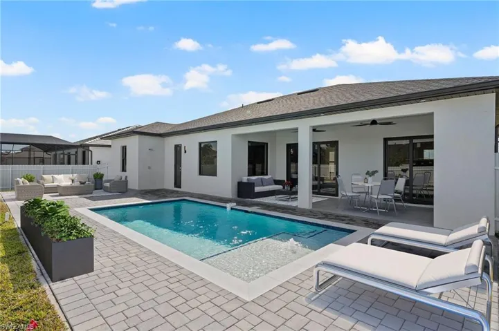 Back of house with fence, a patio, an outdoor living space, and stucco siding