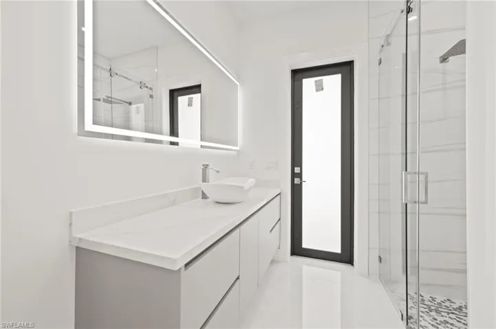 Full bathroom with a marble finish shower and vanity