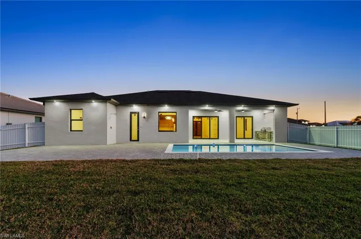 Rear view of property with a lawn, a fenced backyard, ceiling fan, a patio area, and stucco siding