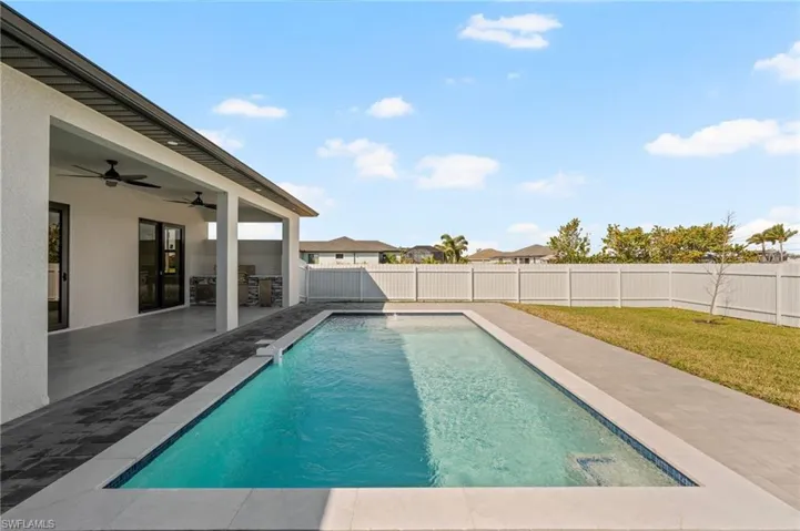 View of swimming pool with a fenced in pool, a patio, a lawn, a ceiling fan, and a fenced backyard