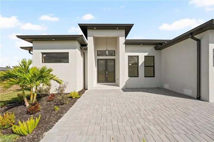 Doorway to property featuring crawl space, a patio area, visible vents, and stucco siding